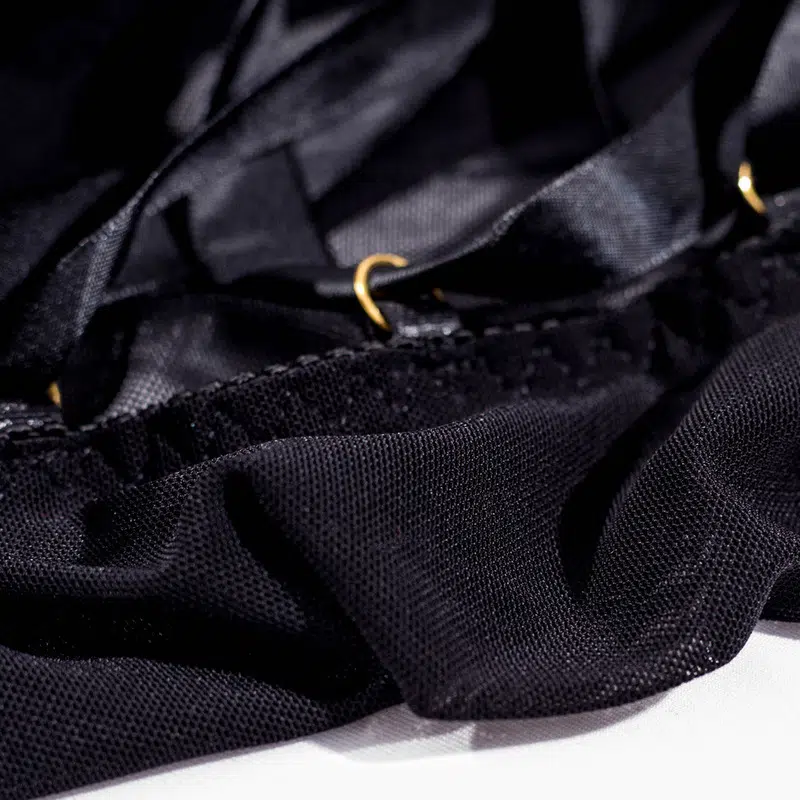Camisa negra de malla transparente con detalles abiertos en la espalda