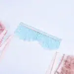 Conjunto de sutiã de renda transparente elegante azul claro com detalhes em penas coloridas Harter