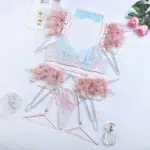 Conjunto de sutiã de renda transparente elegante azul claro com detalhes em penas coloridas sobre a vista